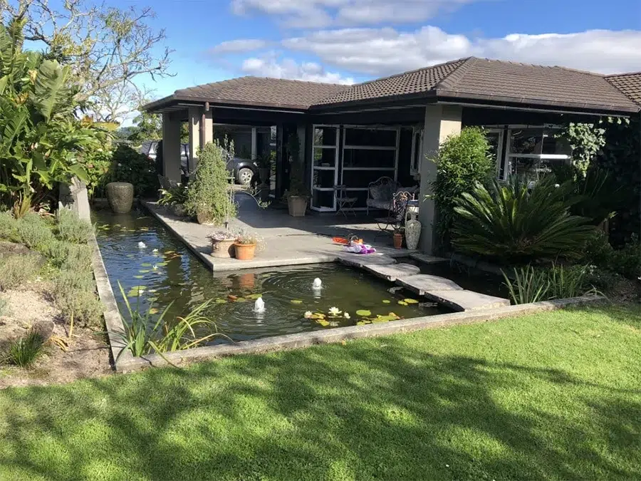 fish pond with water feature near house
